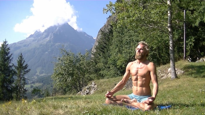 yogi sitting in lotus praticing pranayama breathwork
