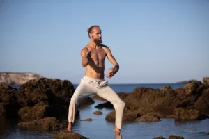 Michaël Bijker practising breathwork on the rocks by the sea