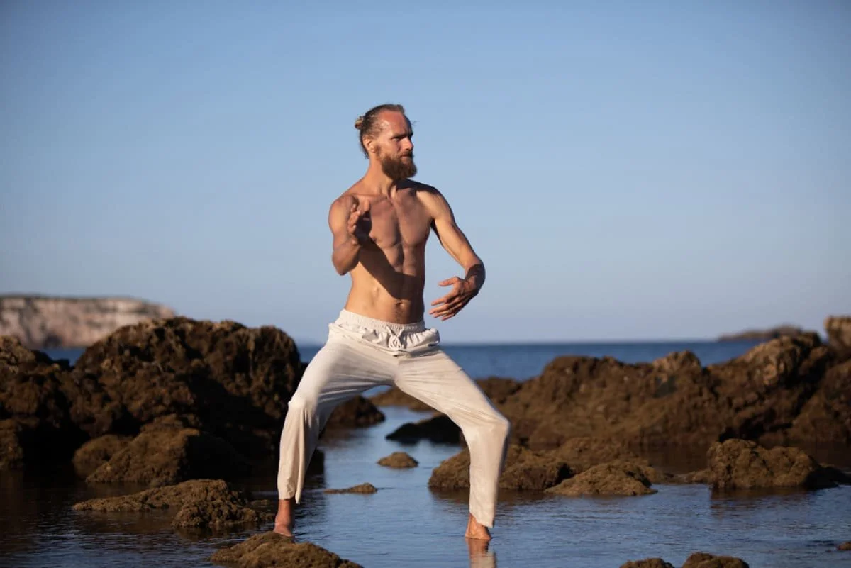 Michaël Bijker practising breathwork on the rocks by the sea